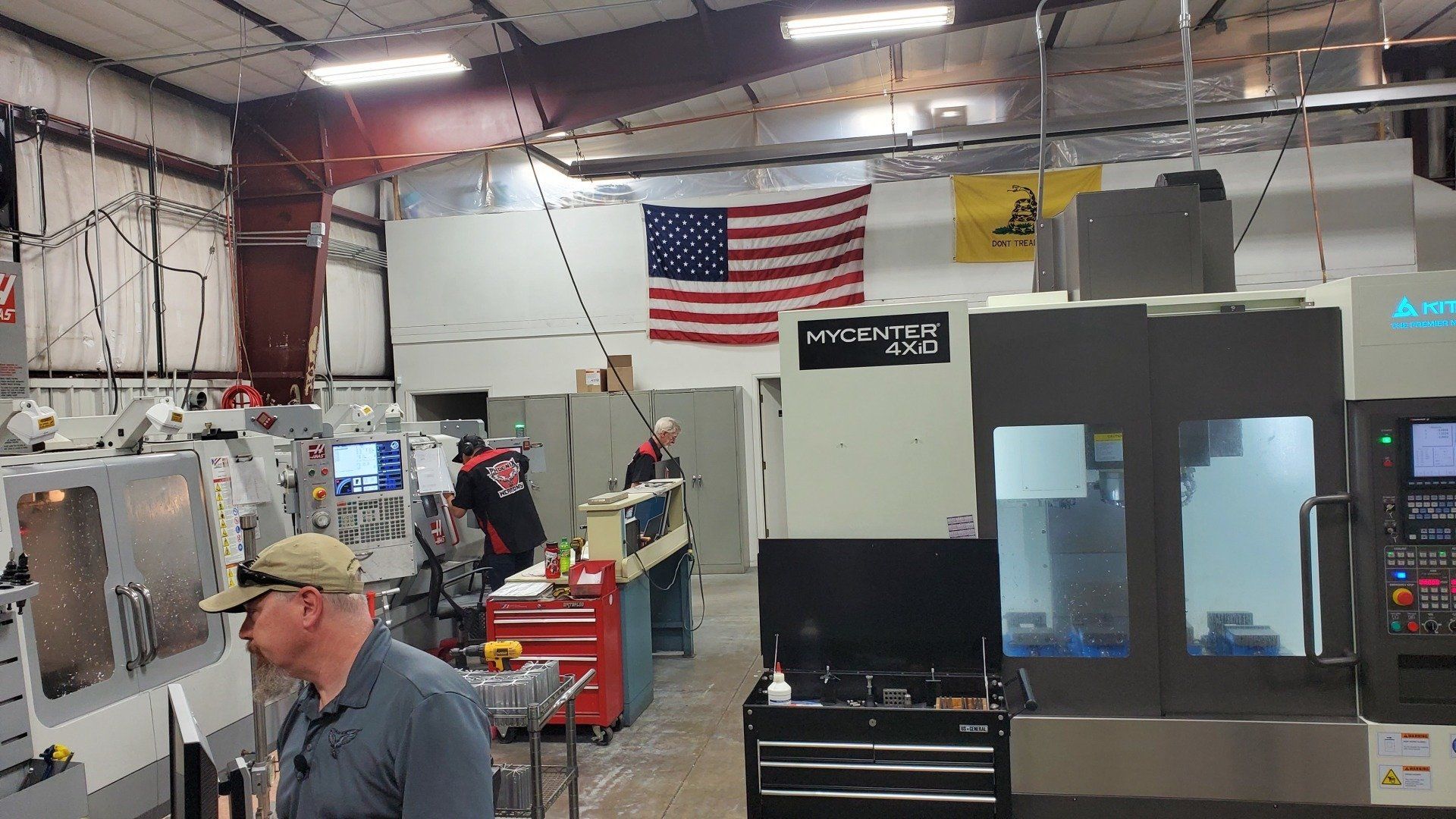 A man is standing in front of a machine in a factory.