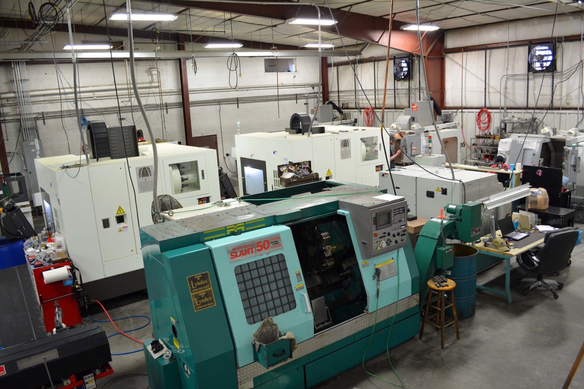 A factory filled with lots of machines and people working on them.