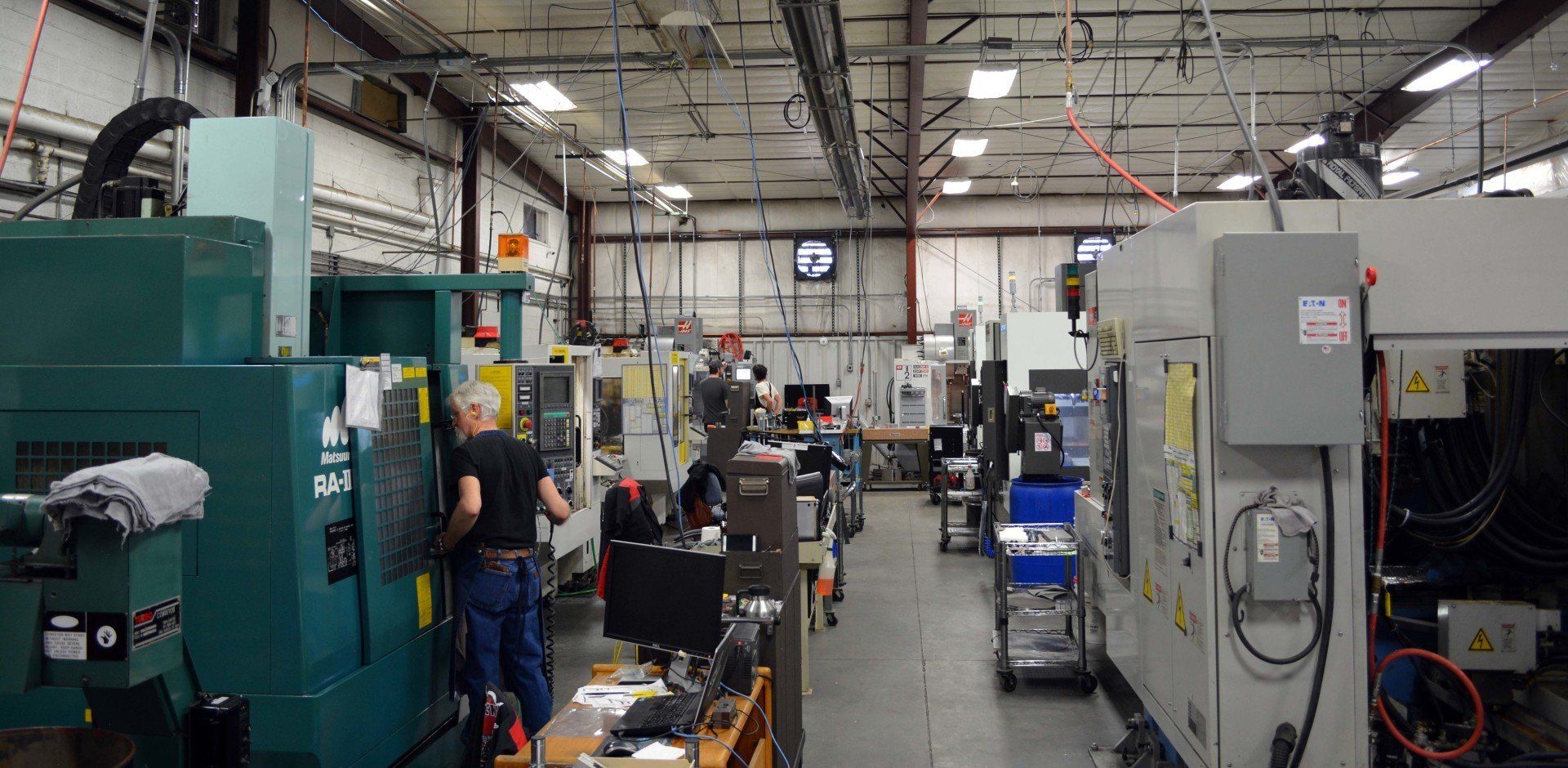 A factory filled with lots of machines and people working on them.