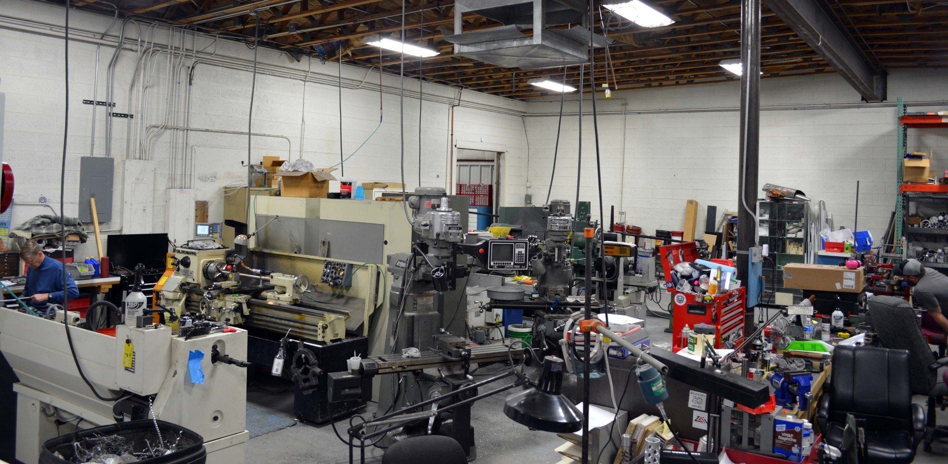 A factory filled with lots of machines and people working on them.