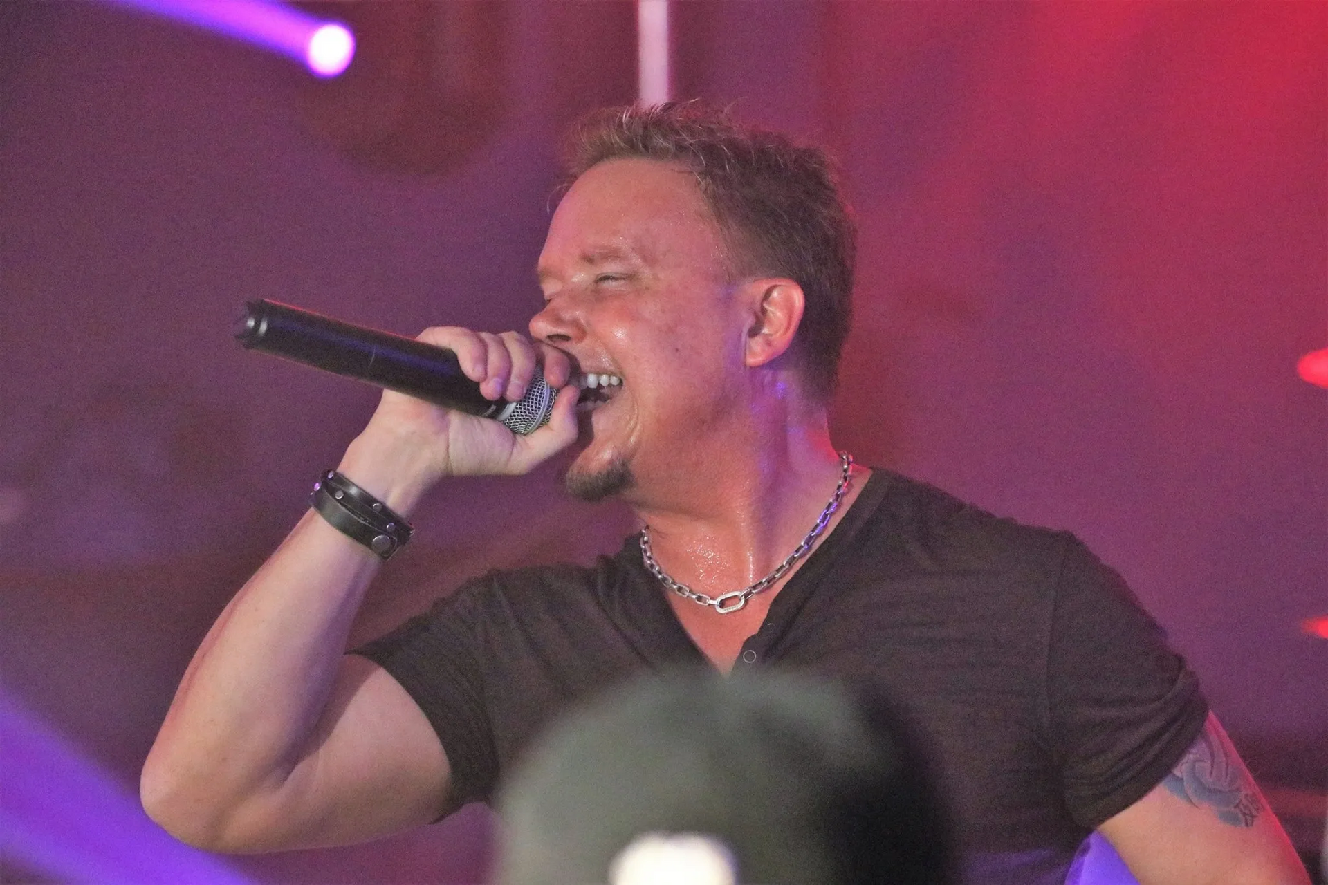 A man is singing into a microphone on a stage.