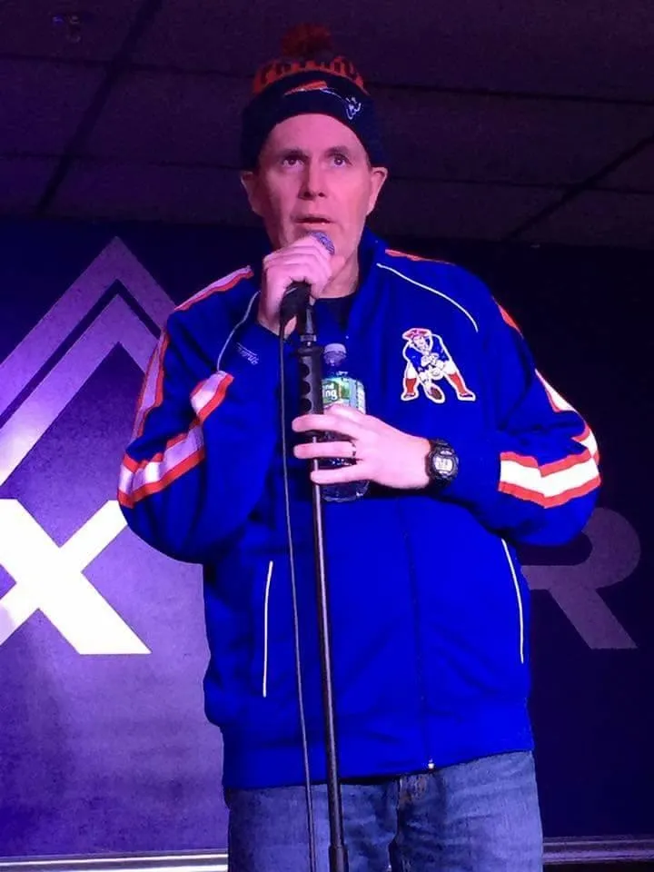 A man wearing a blue jacket with the letter a on it