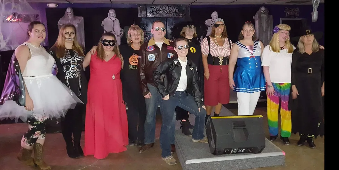 A group of people are posing for a picture in front of a microphone.