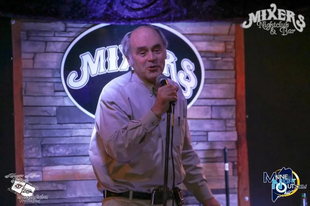 A man stands in front of a sign that says mixers