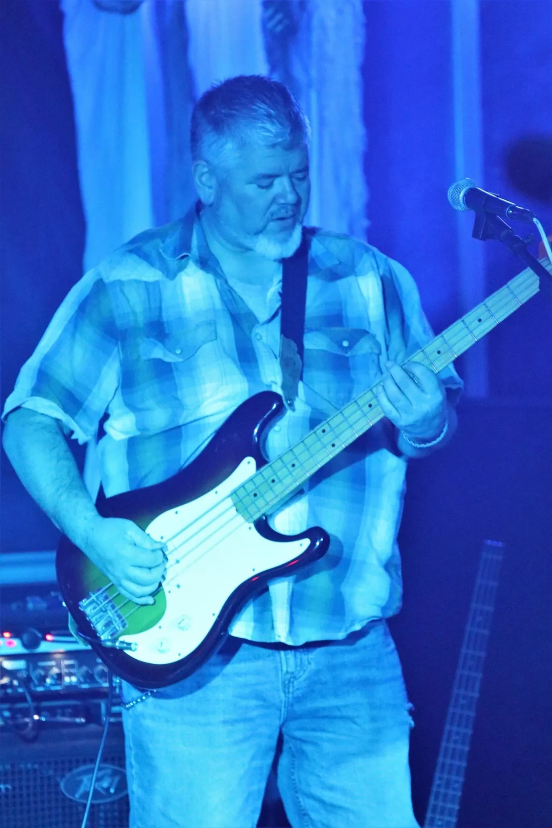 A man is playing a guitar and singing into a microphone.