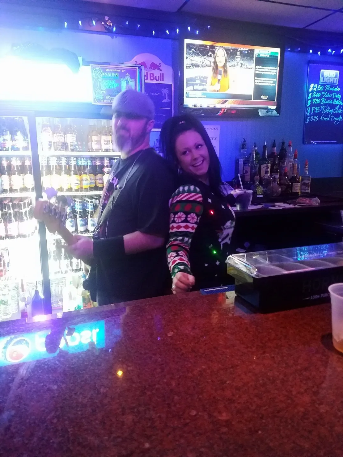 A man and a woman are posing for a picture at a bar