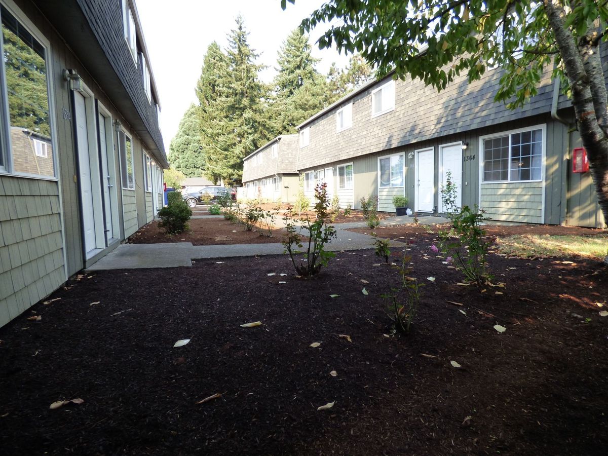 a row of apartment buildings with trees in the background