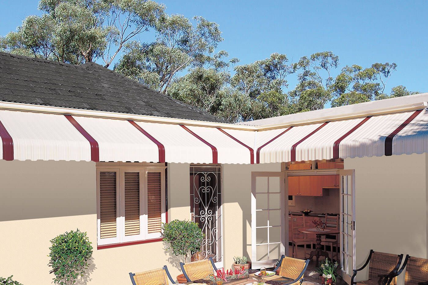 Cream and maroon striped awning over a beige exterior with a patio and open door.