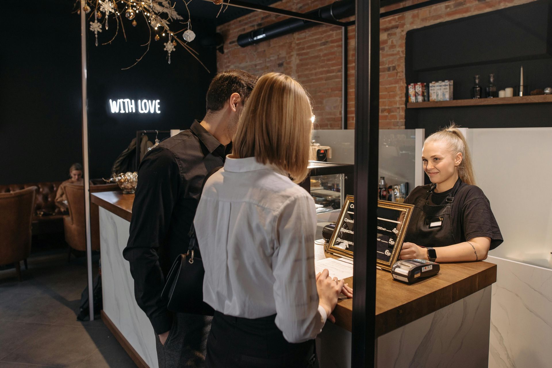 Two customers at a jewelry counter with a smiling clerk in a modern store