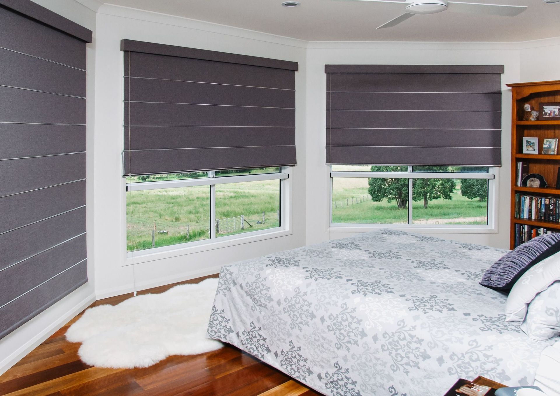 A Bedroom With a Large Bed and a Bookshelf — Curtain Force NQ in Garbutt, QLD