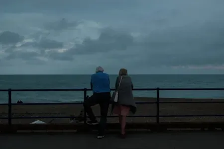 a man and woman looking out at the ocean