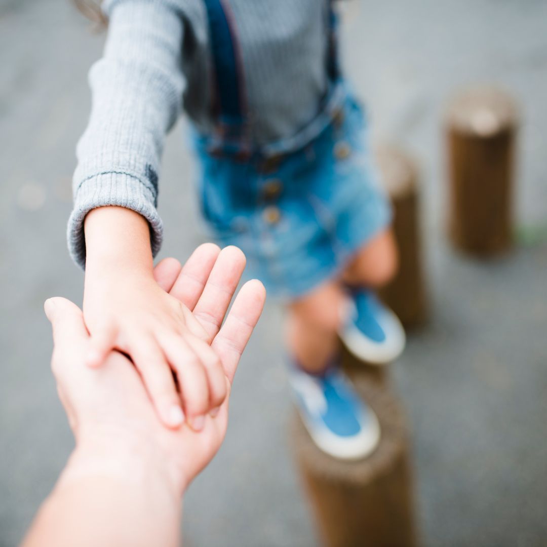 child holding parent's hand