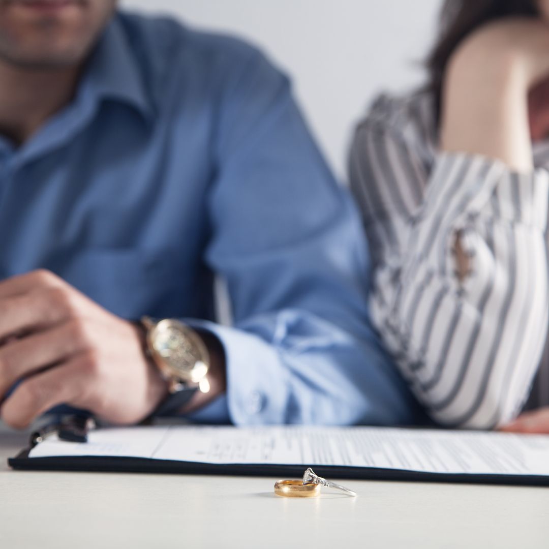 couple sitting at table with rings on table