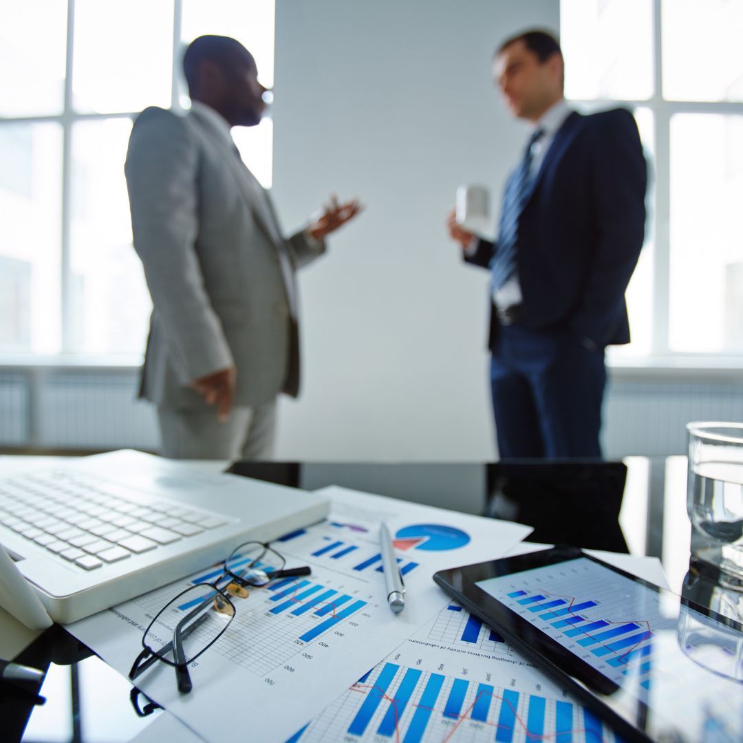 two people talking in the background of an office with charts