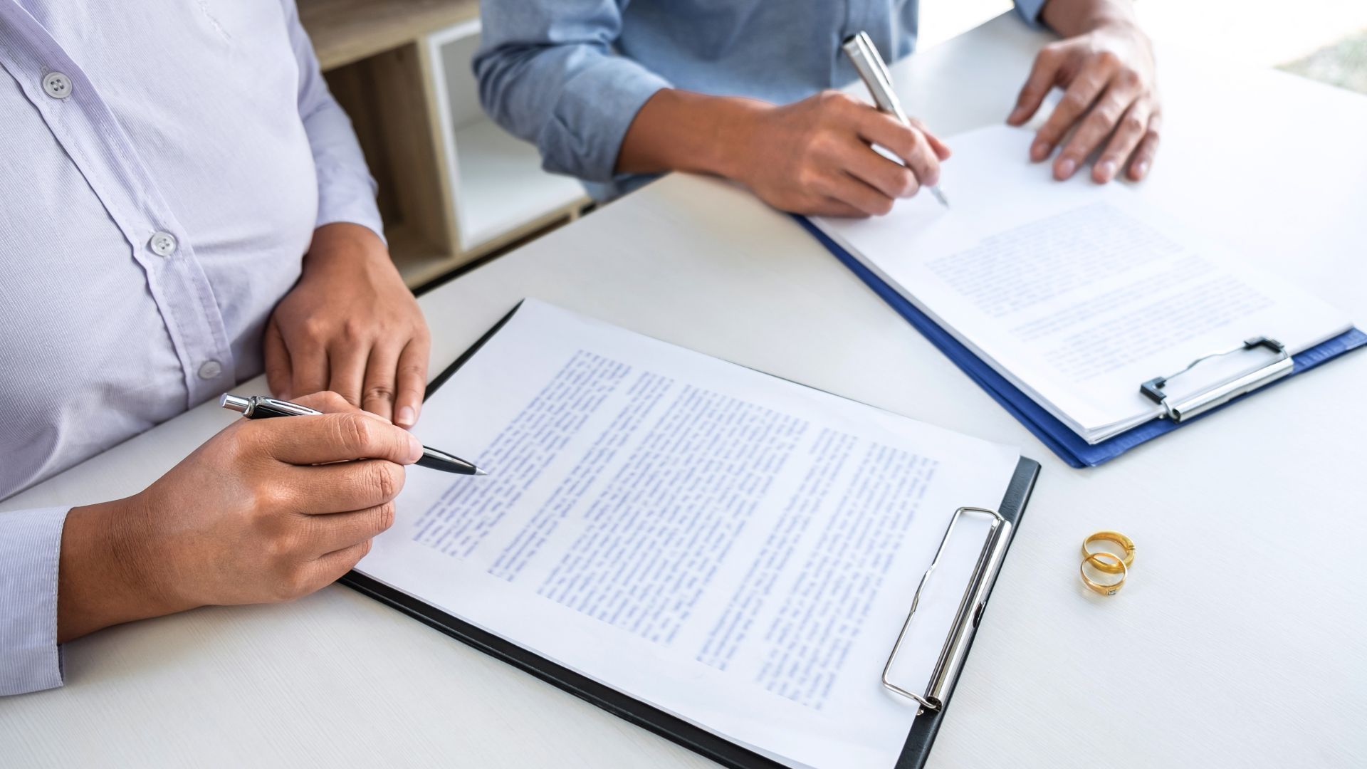 Two people signing legal documents