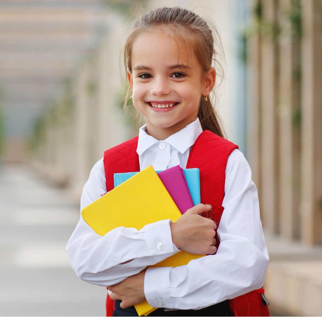 child smiling holding school supplies