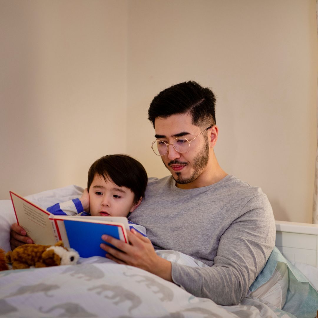 dad reading a bedtime story to his son