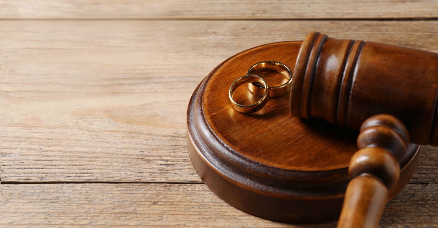 closeup of wedding bands in between two people's folded hands