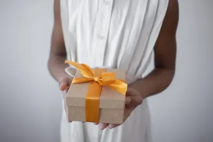 a person wearing white and holding a gift