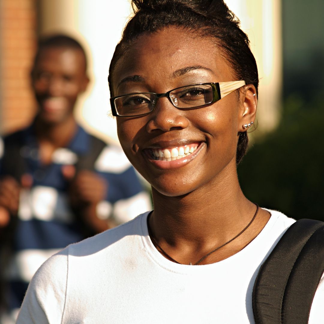 a smiling young woman holding a backpack