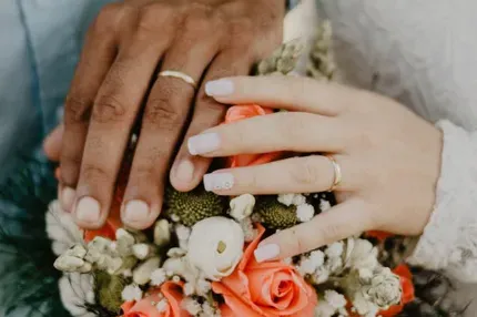 a man and woman's hand on a wedding flower bouqet