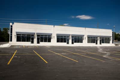 White commercial building with a large parking lot