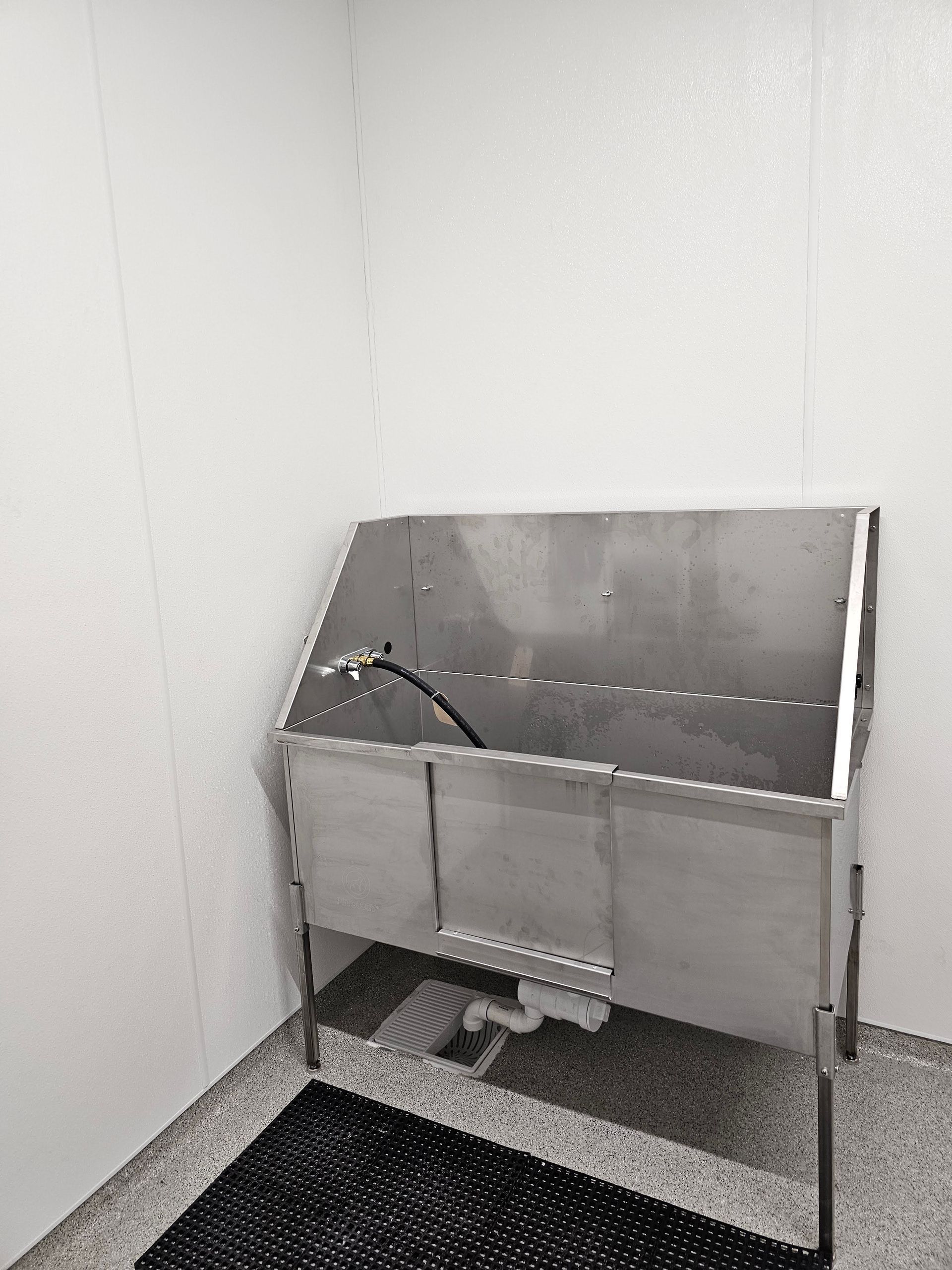 Person in red uniform uses a tablet to view inside a well. Gloves and a control panel are visible.