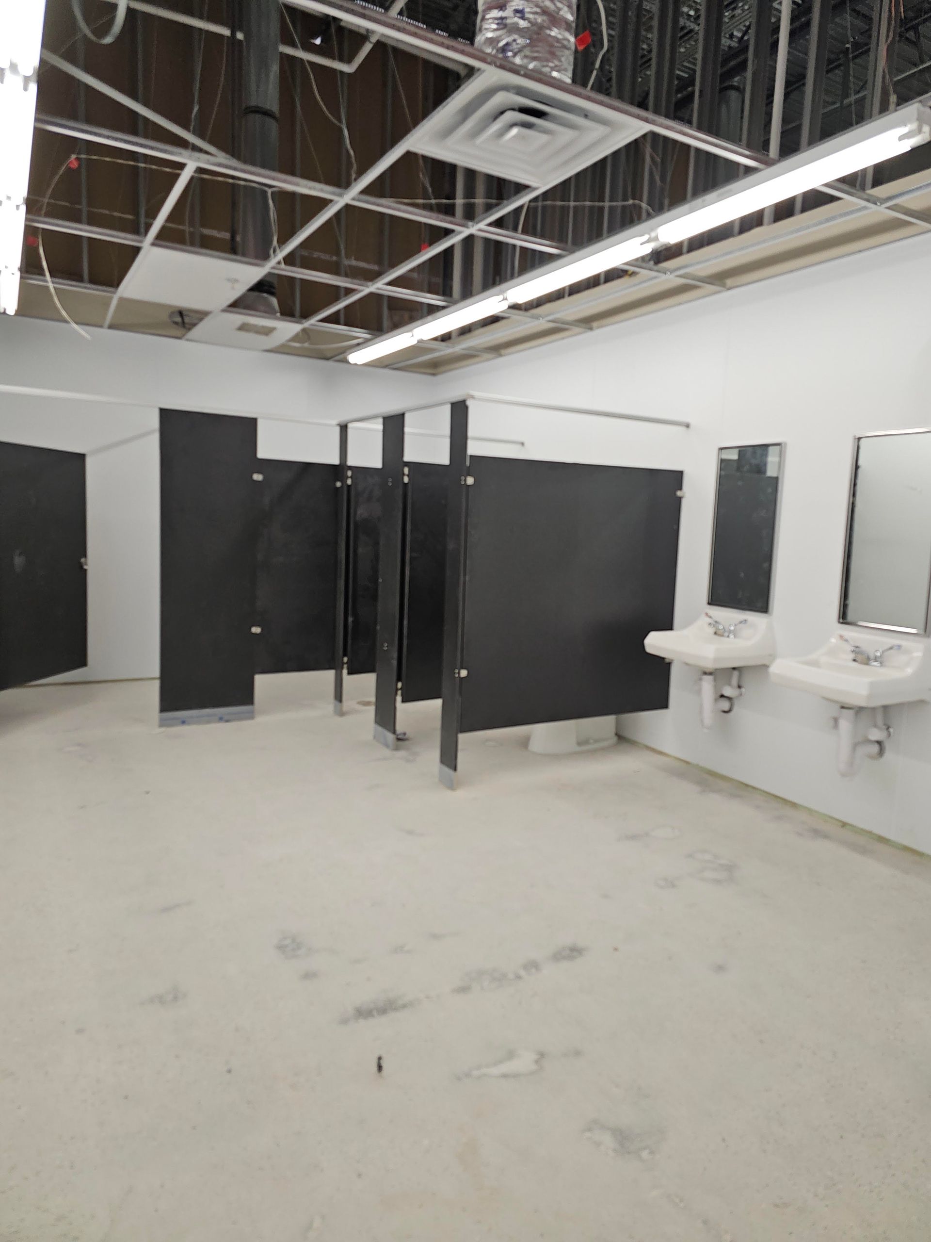 Colorful industrial pipes and valves against a concrete wall.