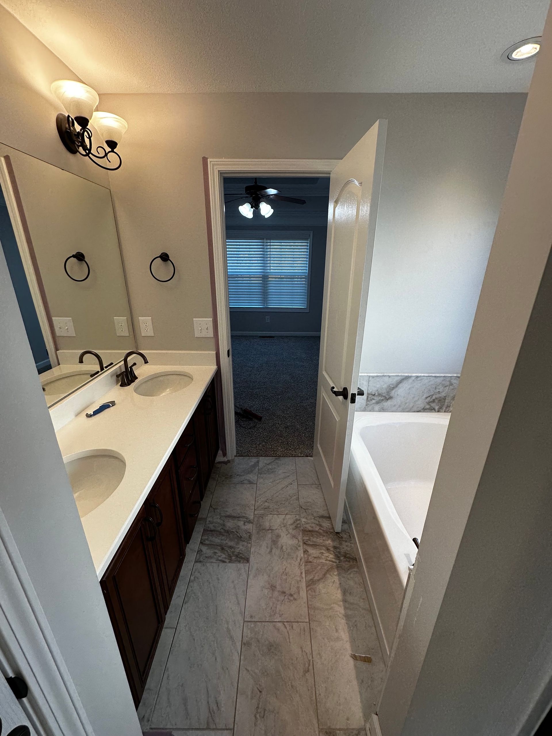 White plumbing pipes inside a wall opening, including a P-trap, connected to wood framing.