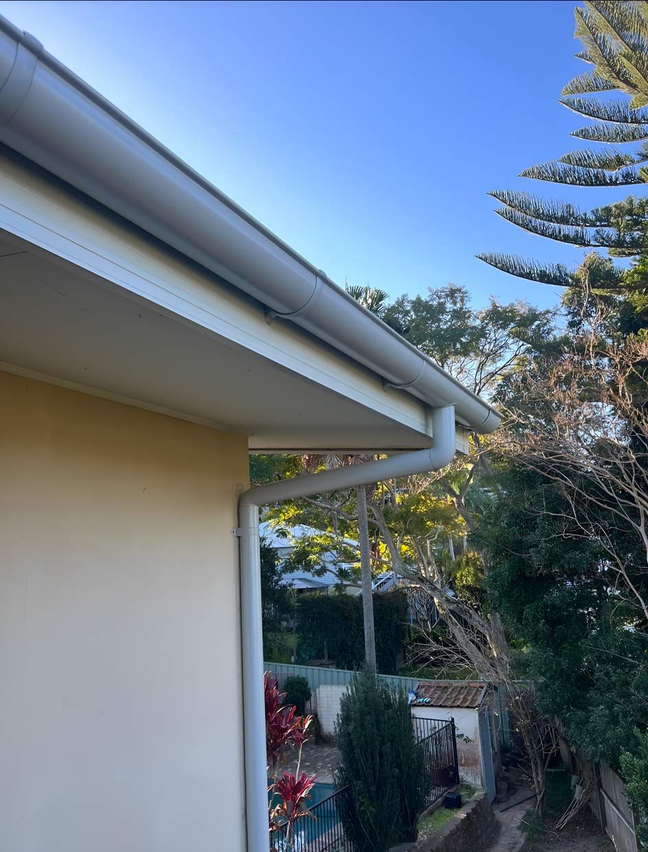 A White Gutter on the Side of a House With Trees in the Background — Gutterworx in Long Jetty, NSW
