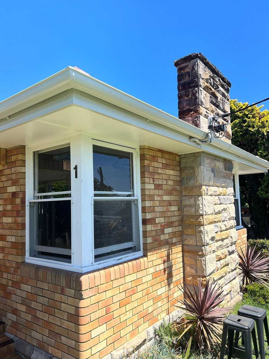 A Brick House With a White Window and a Chimney — Gutterworx in Wamberal, NSW