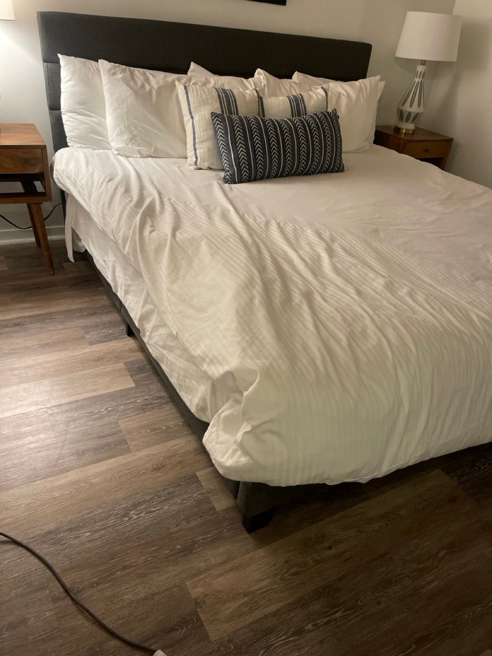 A bed with white sheets and pillows in a bedroom