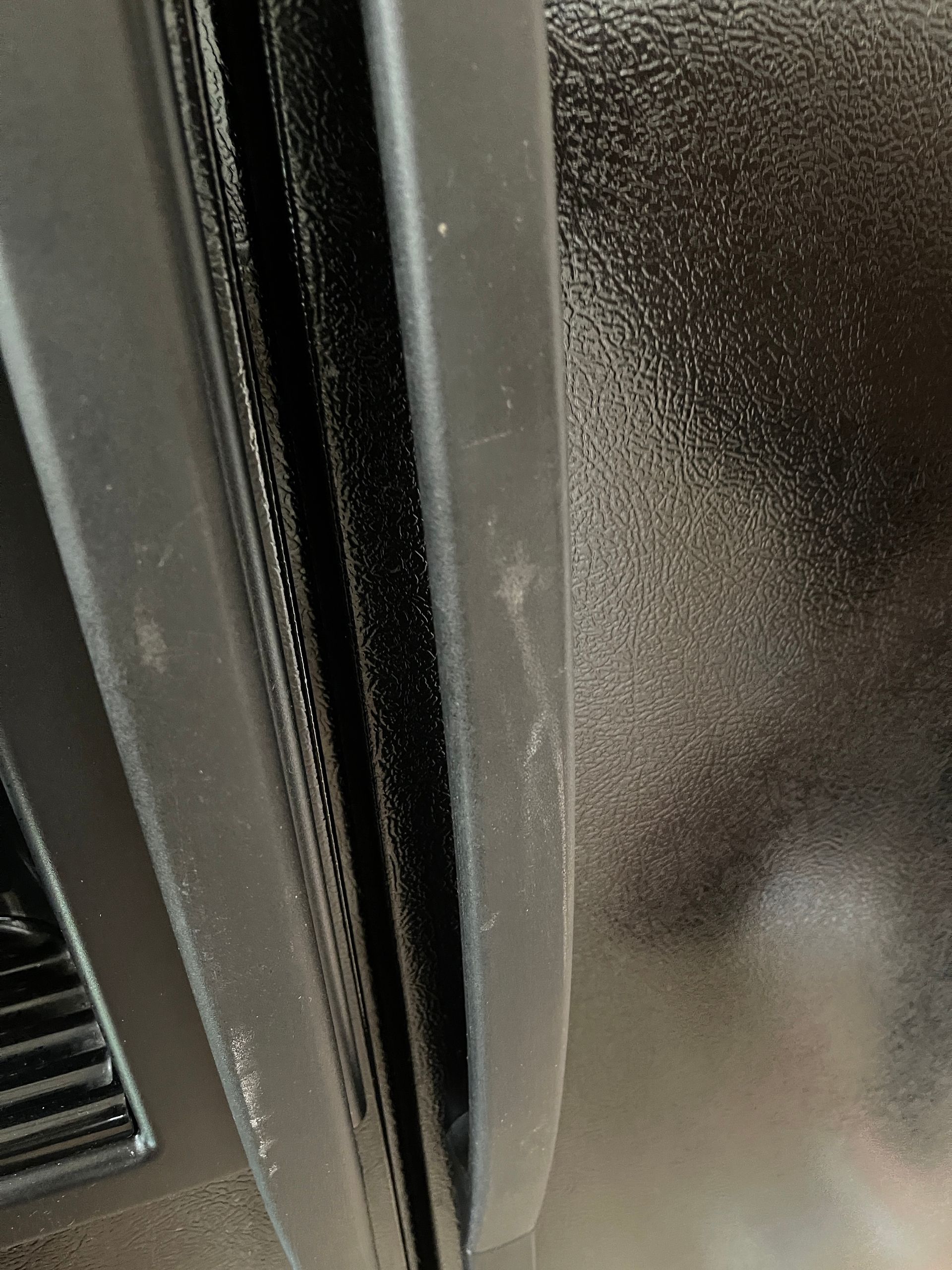 A close up of a refrigerator door with a scratch on it.