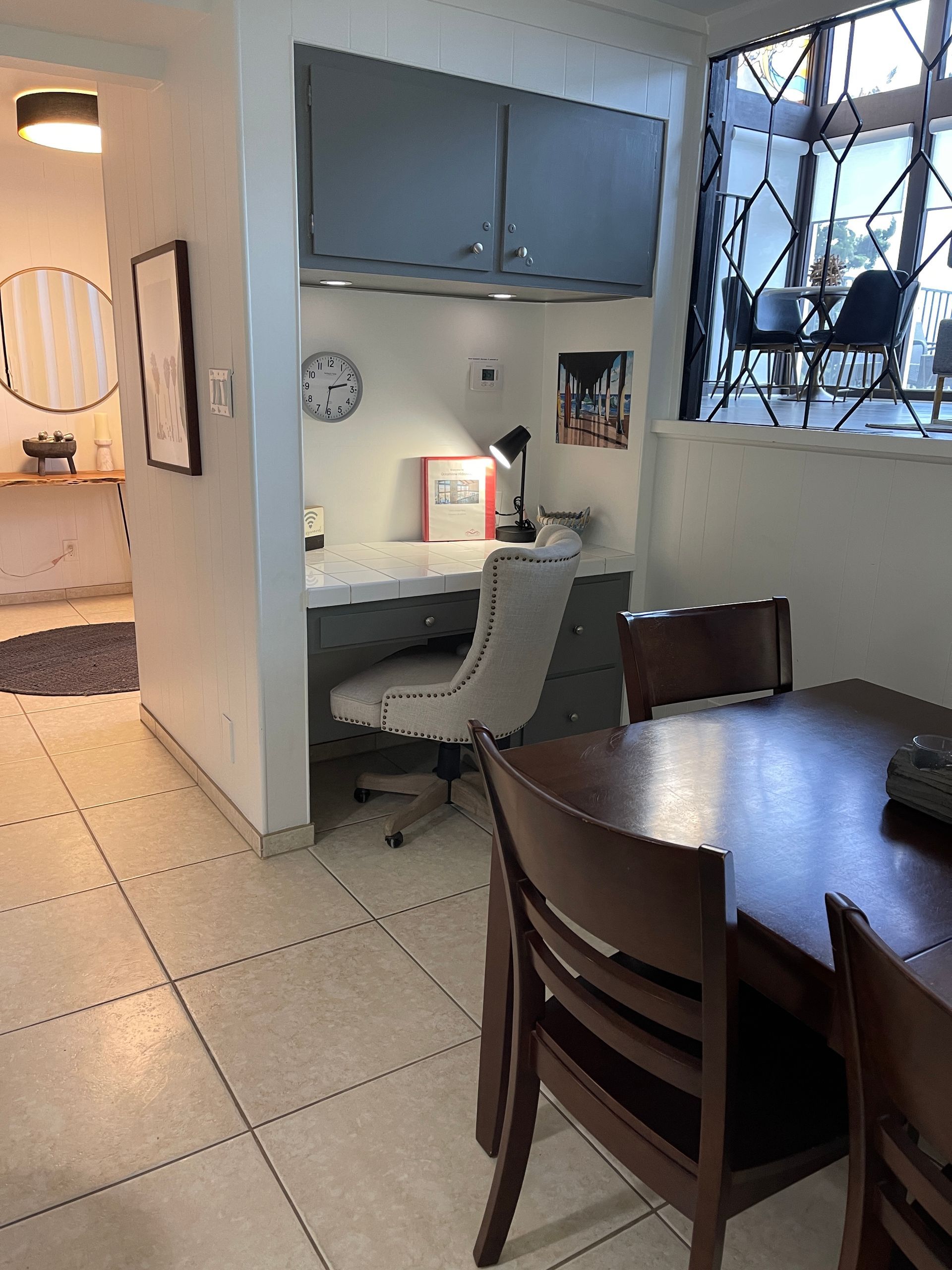 A dining room with a table and chairs and a desk
