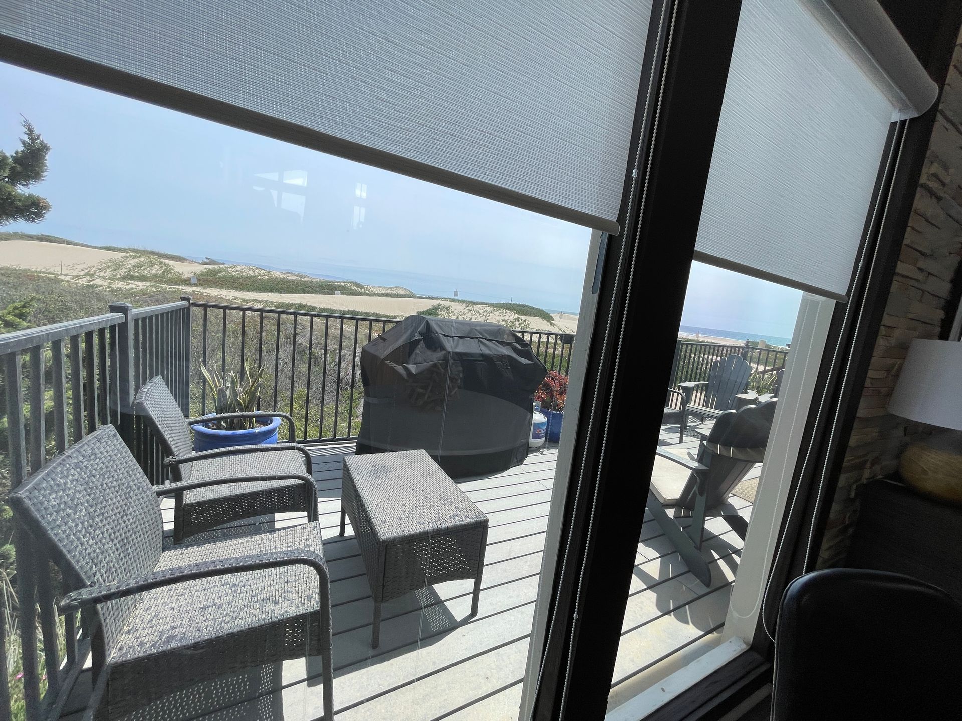 A balcony with chairs and a table with a view of the ocean