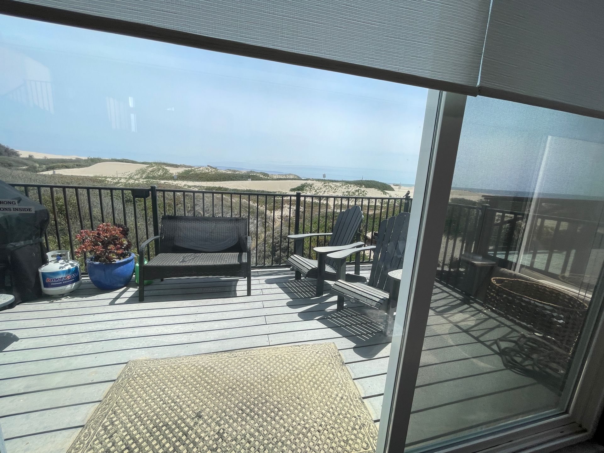 A deck with a couch and chairs and a view of the ocean