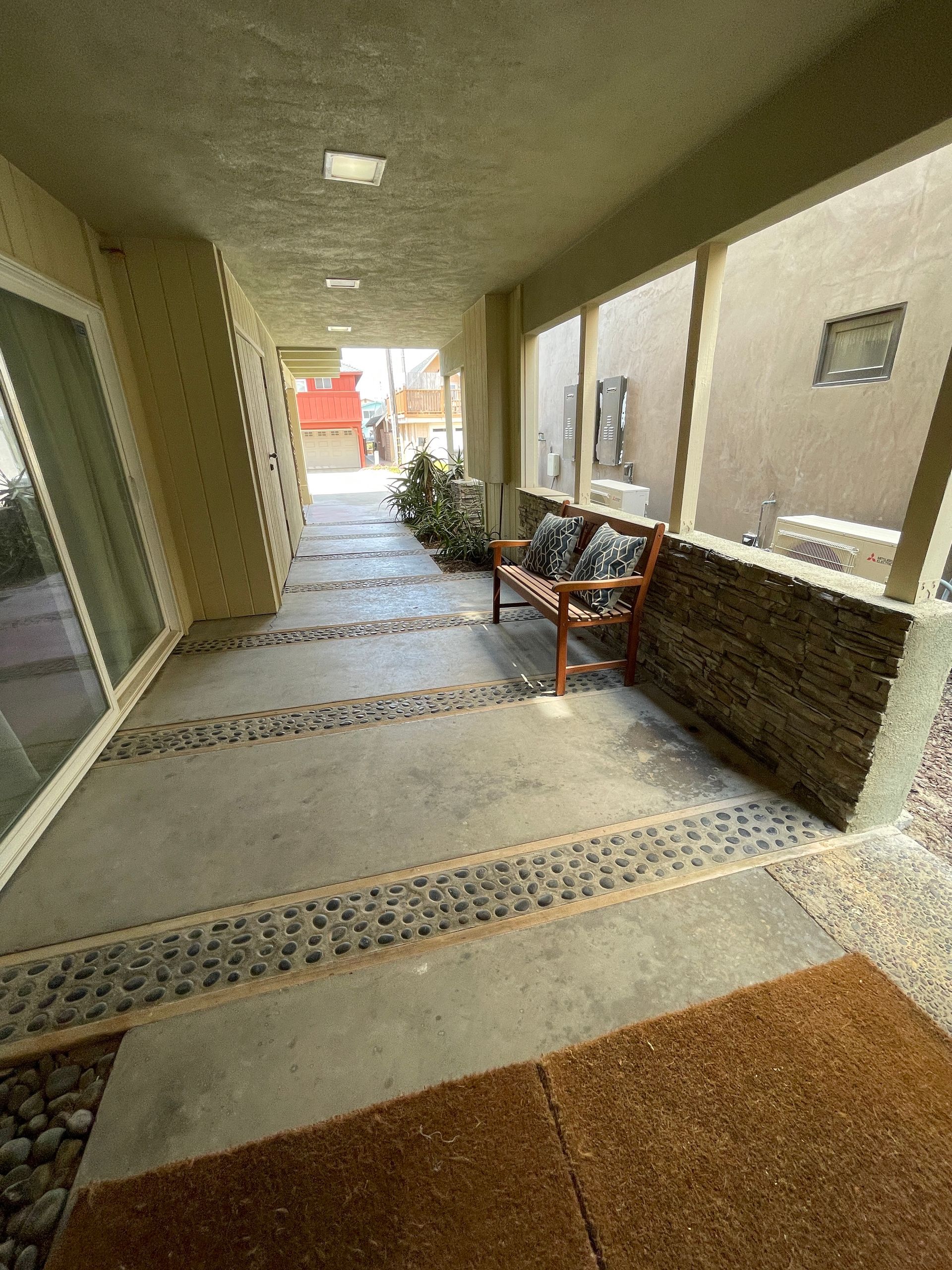 A porch with a bench and sliding glass doors