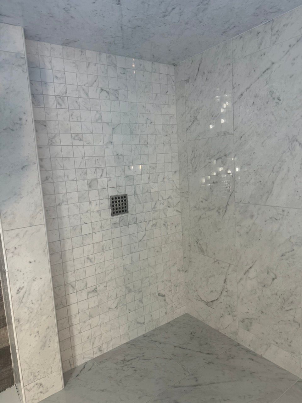 A bathroom with marble tiles on the walls and floor