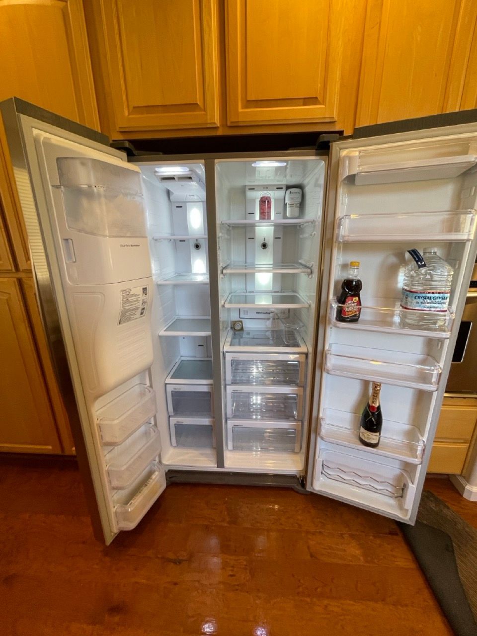 A refrigerator with its doors open in a kitchen.