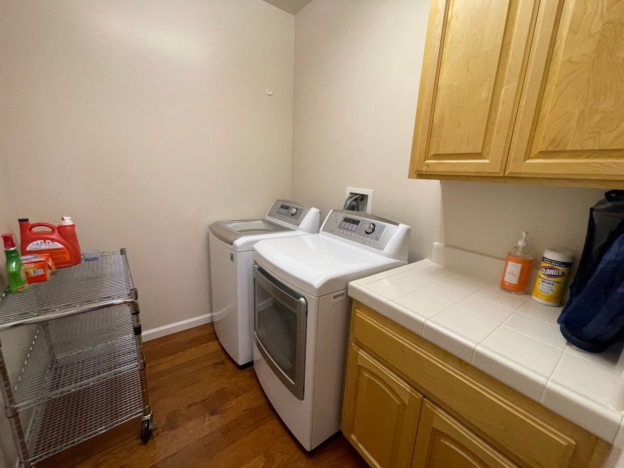 A laundry room with a washer and dryer and wooden cabinets.