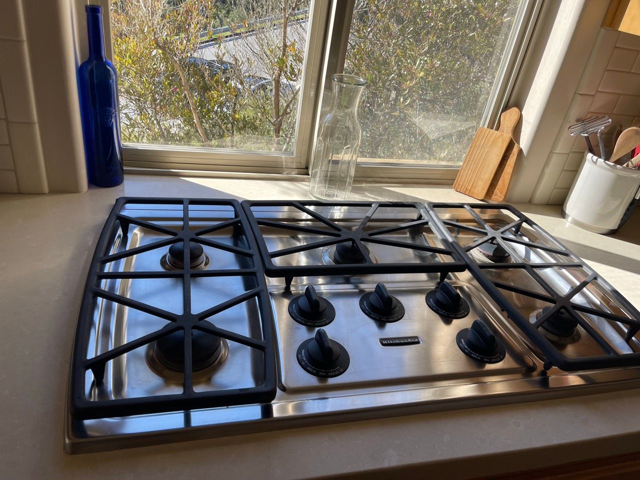 A stove top oven is sitting on a counter next to a window.