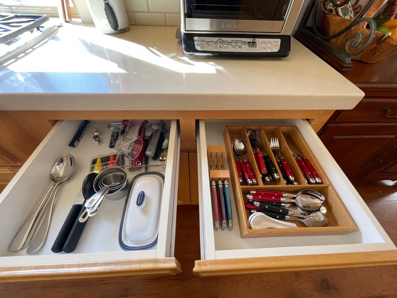 A kitchen drawer filled with utensils and a toaster oven