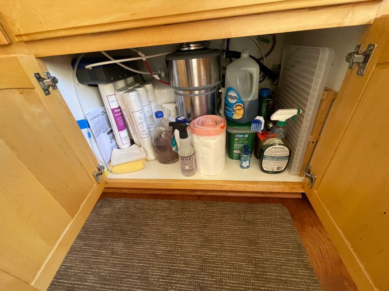 A kitchen sink with a lot of cleaning supplies underneath it