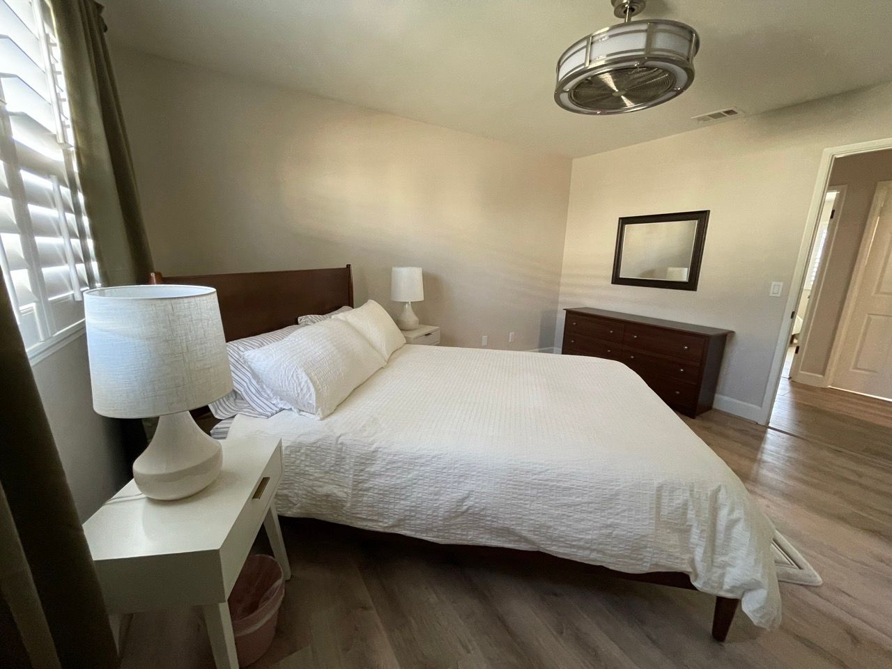 A bedroom with a king size bed and two lamps