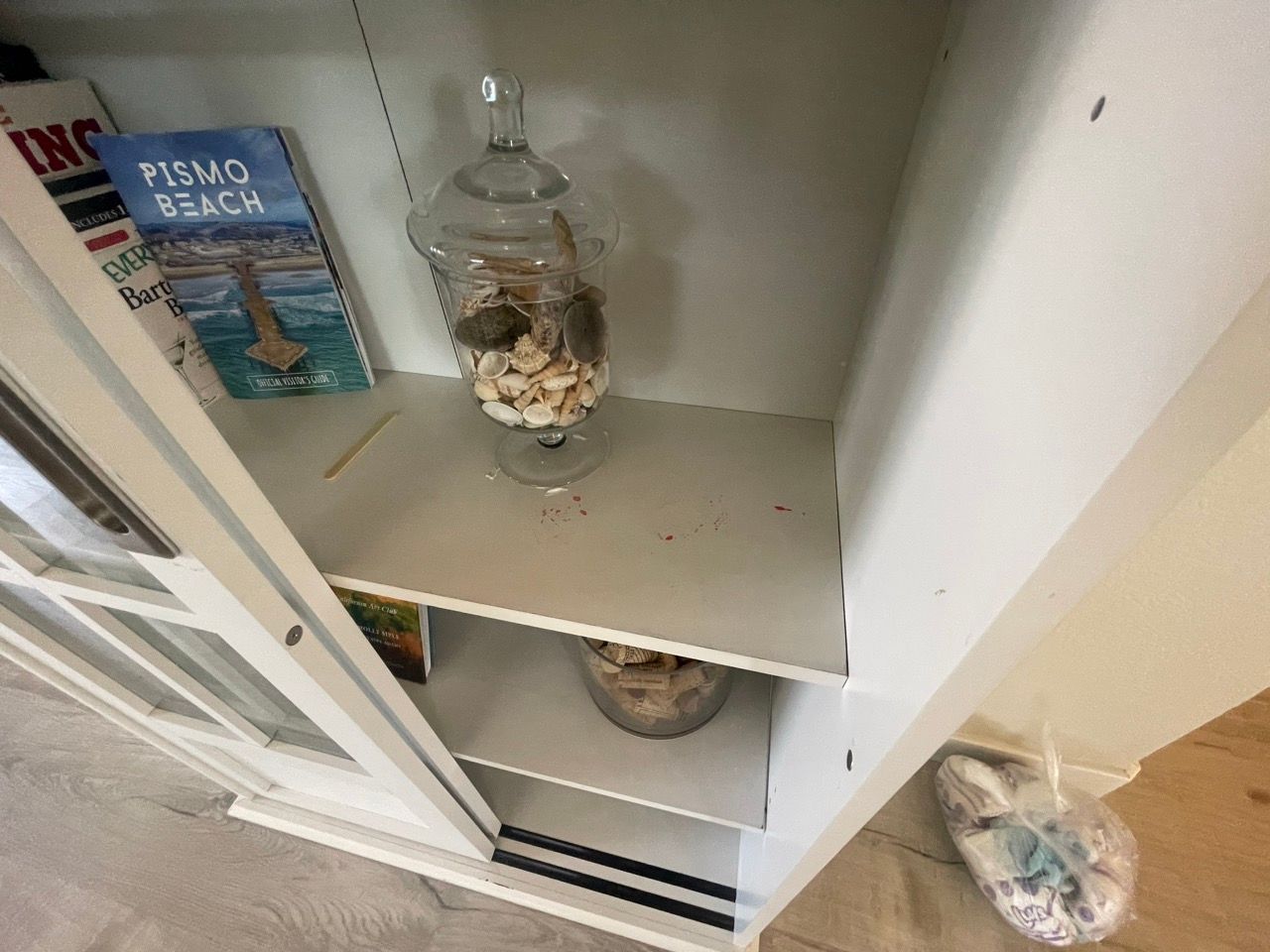 A book called pismo beach sits on a white shelf