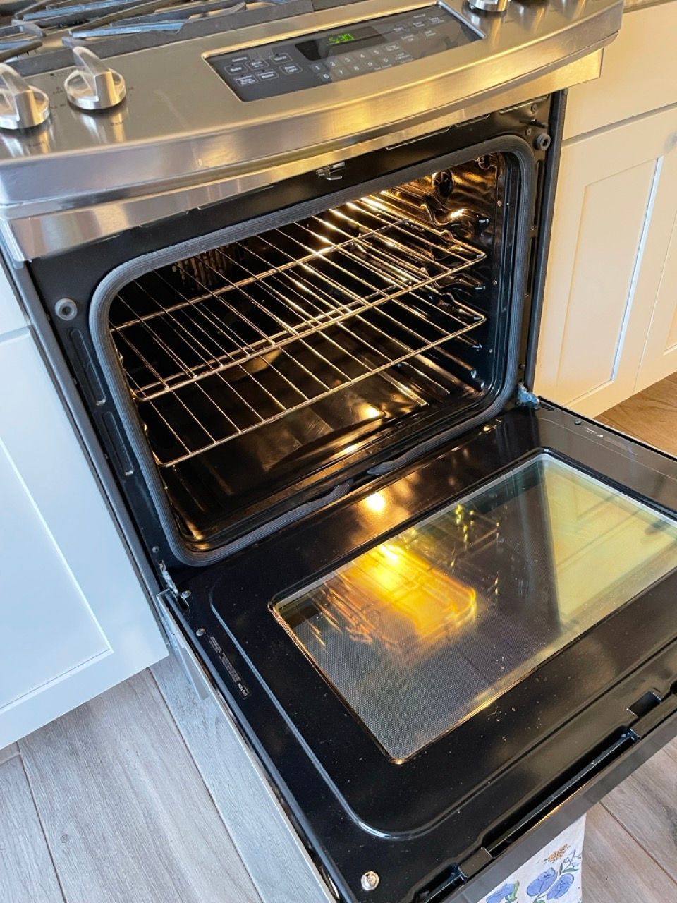 A stove with the door open and a piece of food in it