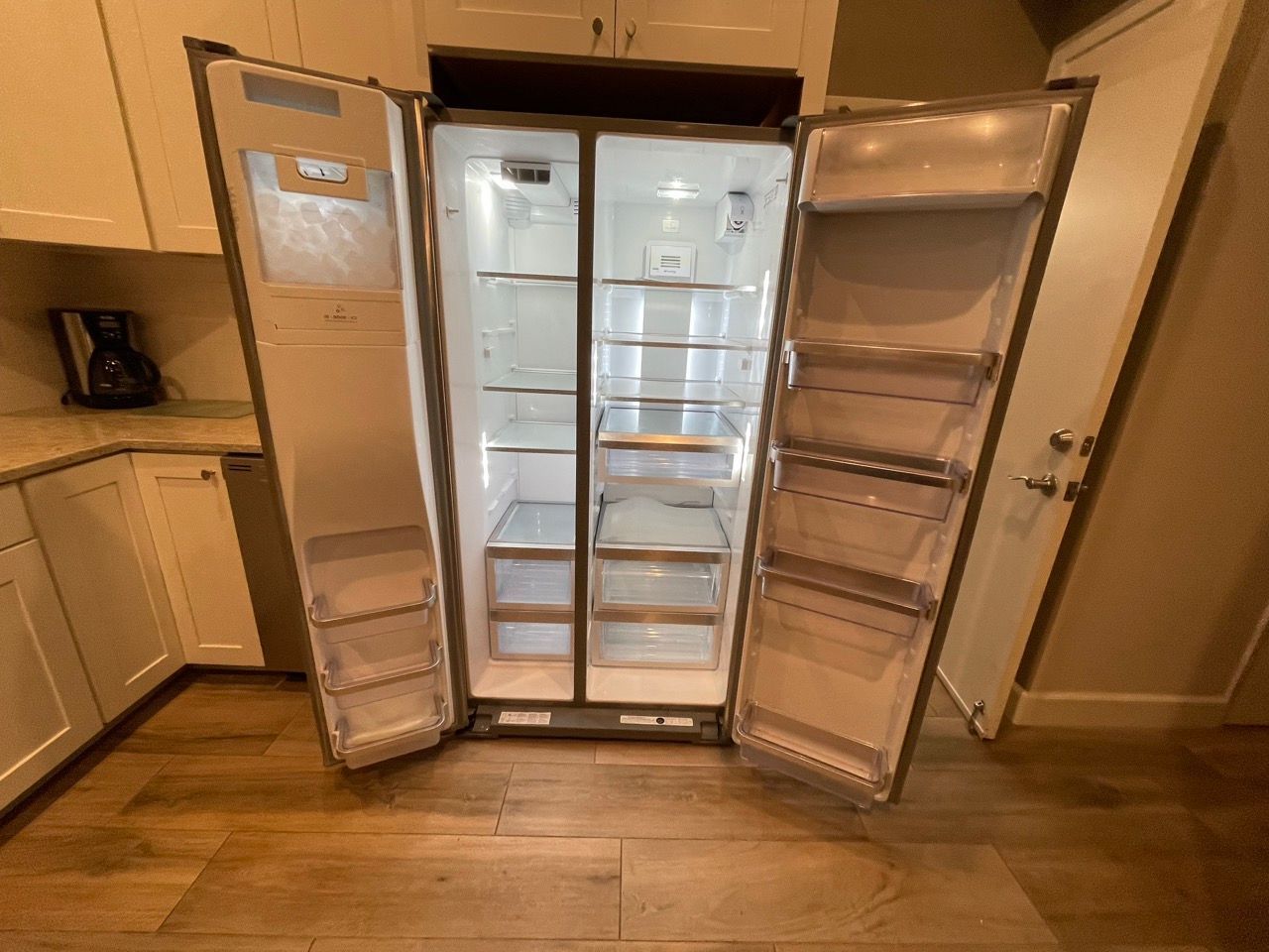 A refrigerator with the doors open in a kitchen