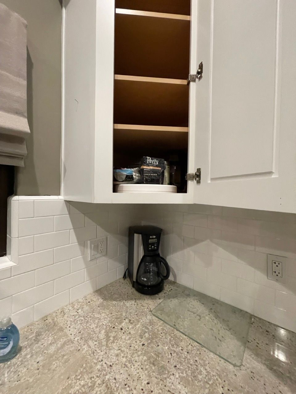 A coffee maker is sitting on a counter in a kitchen.