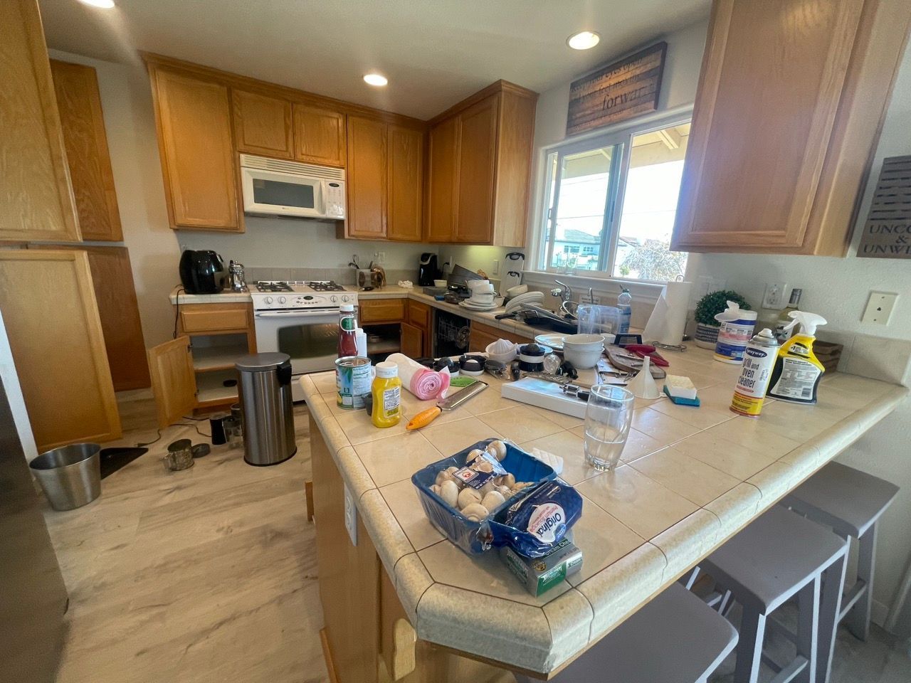 A kitchen with a lot of cleaning supplies on the counter