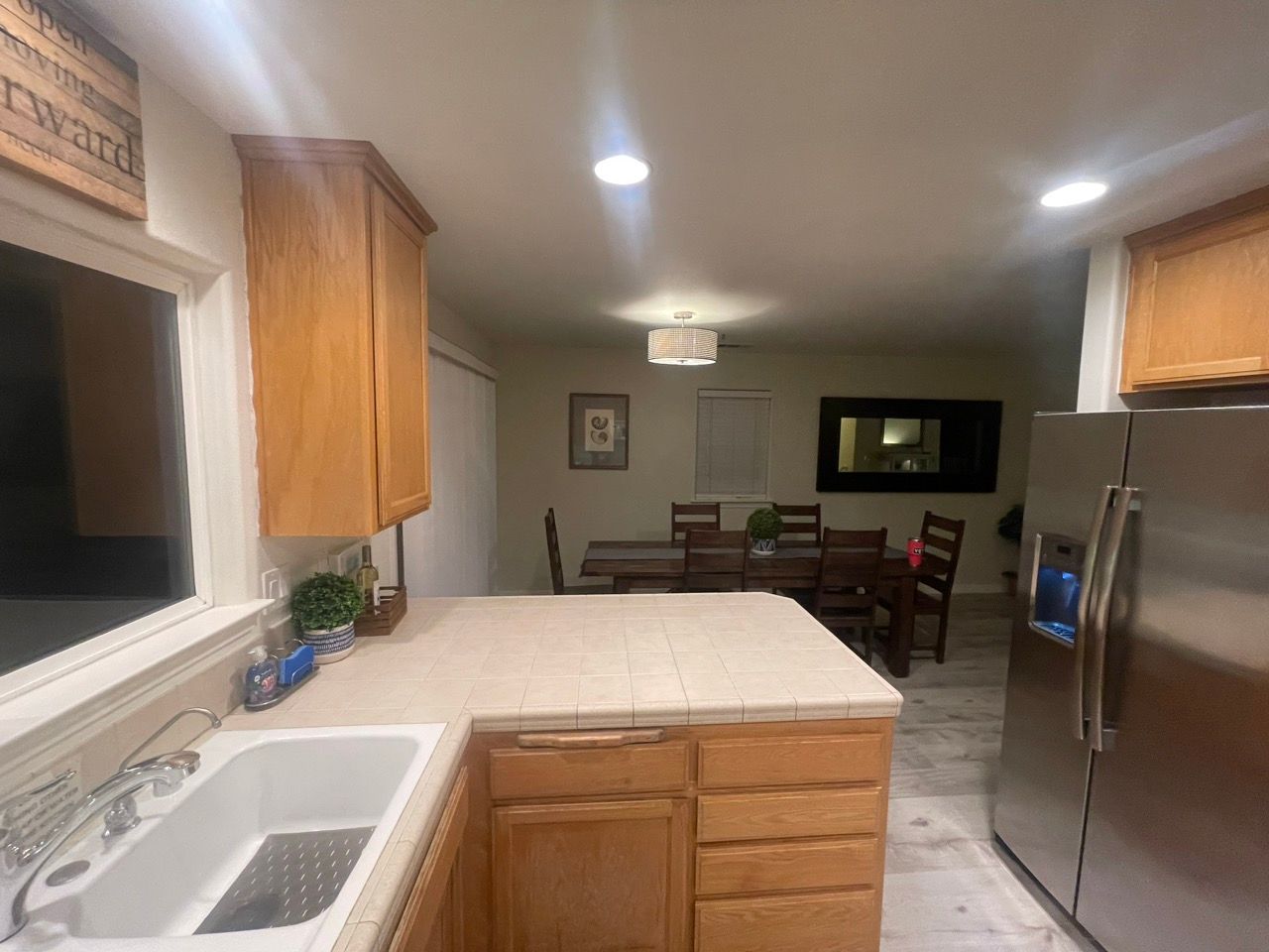 A kitchen with a sink and a stainless steel refrigerator